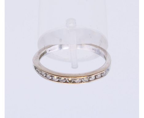 An 18 K white gold diamond half hoop eternity ring. Ring size P.
