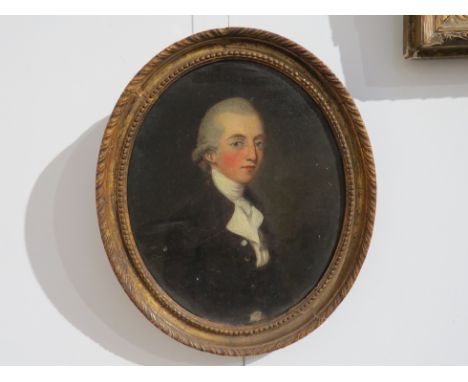 An early Victorian oil on canvas, depicting a portrait of a young man with frock coat and neck stock, original gilt oval fram