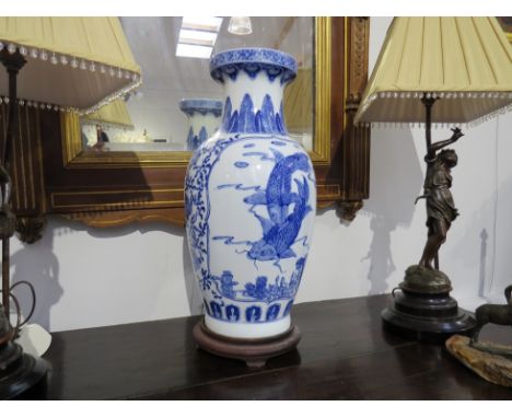 A modern Chinese blue and white vase with fish design, on hardwood base, previously converted to a lamp, cracked, 47cm tall. 