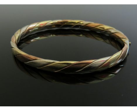 A 9ct three tone gold stiff hinge bangle, 18.9g
