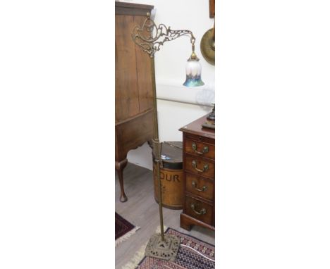 A late Victorian brass and iron standard lamp with mottled lustre glass shade and pierced support