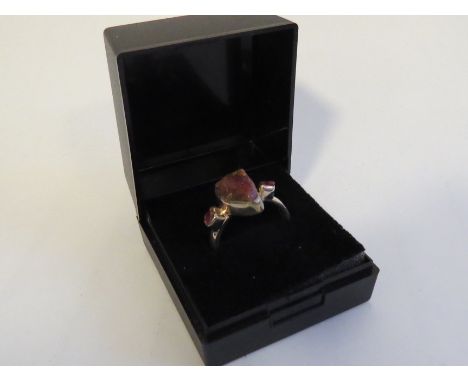 A rough cut ruby ring the centre ruby flanked by smaller rubies, shank stamped 925