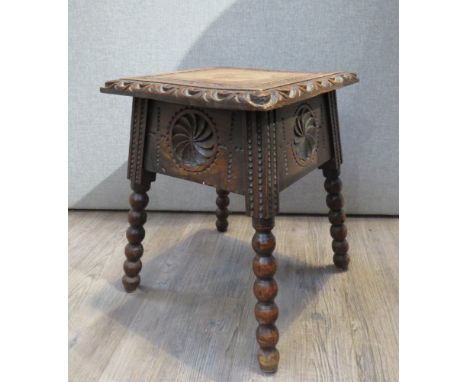 A Victorian carved oak stool of square form, deep frieze, on bobbin supports. Monks Hall Estate 