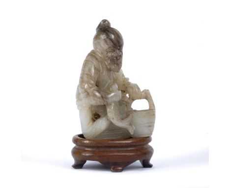 Jade carving of a fisherman Chinese, 19th Century the seated figure holding a fish in his right hand and a small basket in hi