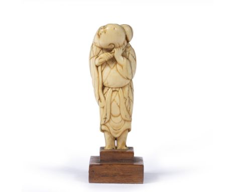 Carved netsuke Japanese, Meiji the standing figure holding a gourd over his left shoulder, mounted on a wood block 8l5cm high