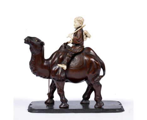 Wood and ivory okimono Japanese, late Meiji carved as a Mongolian traveller astride a camel, the figure seated between humps 