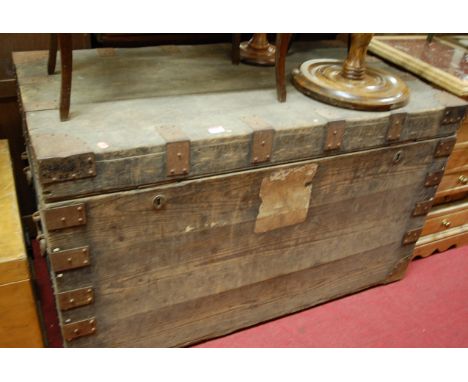 A late 19th century stained pine and metal bound hinge-top travelling trunk of good size 