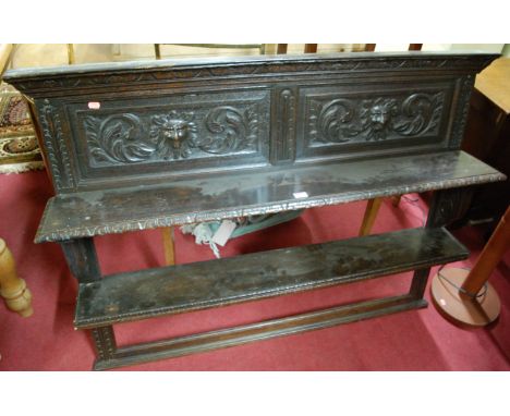 A circa 1900 carved and panelled oak two tier wall shelf