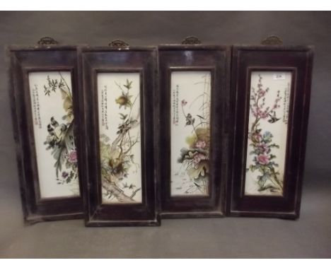 A set of four Chinese porcelain panels with painted enamel decoration depicting birds amongst fruiting branches, 10" x 23" 