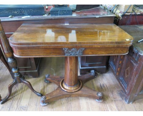 An early Victorian rosewood foldover card table, the frieze with acanthus carved panel on a turned tapering stem, platform ba