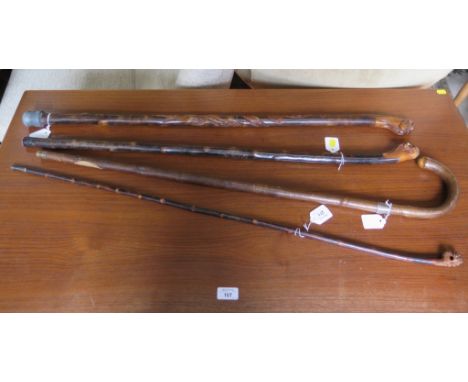Three Chinese canes, one carved with dogs head and ball, the other two carved with the heads of elders, and a swordstick (4)