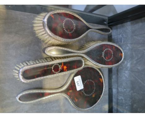 A ladies four piece silver and tortoiseshell brush and comb set