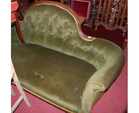 A mid-Victorian walnut framed and green dralon button upholstered three-seater parlour sofa, raised on squat turned forelegs,