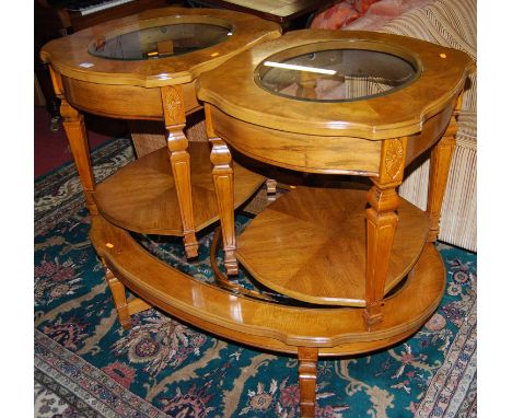 A contemporary burr oak and glass inset oval coffee table, together with a matching pair of two tier lamp tables (3)