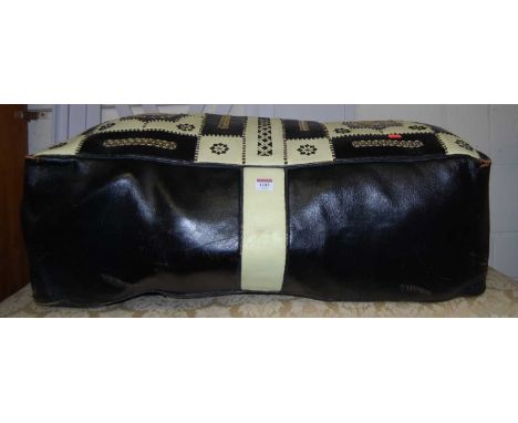 A Nigerian leather and floral needlework embroidered pouffe, length 87cm