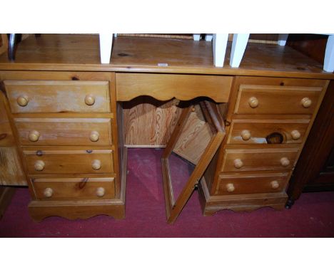 A modern pine kneehole swing mirror back dressing table, having an arrangement of eight drawers, width 122cm