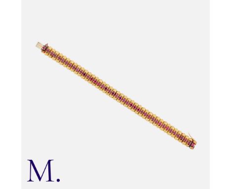 MAUBOUSSIN. A Ruby Bracelet in 18K yellow gold set with round cut rubies along the length of the woven gold bracelet.  Signed