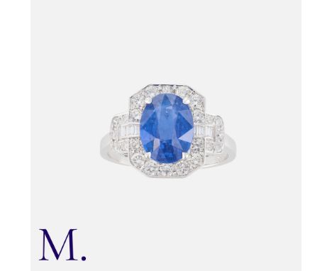A Sapphire And Diamond Cluster Ring in 18k white gold, set with a central oval cut sapphire of approximately 3.40cts, within 