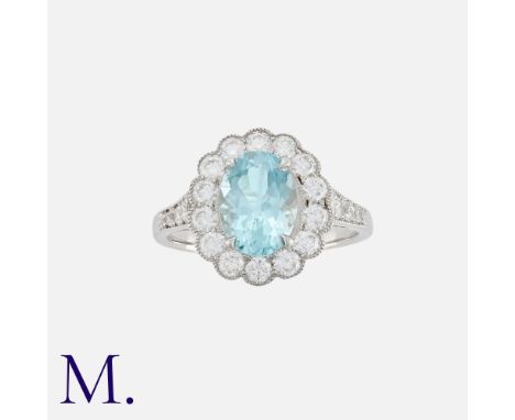 An Aquamarine and Diamond Cluster Ring in platinum, the central oval cut aquamarine of approximately 1.30cts (9x6mm), surroun