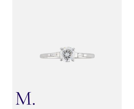 A Diamond Engagement Ring in 18k white gold, set with a principal round cut diamond of approximately 0.60cts, flanked either 