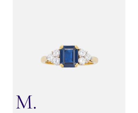 A Sapphire And Diamond Ring in 18k yellow gold, the central step cut sapphire of approximately 1.50cts flanked either side by