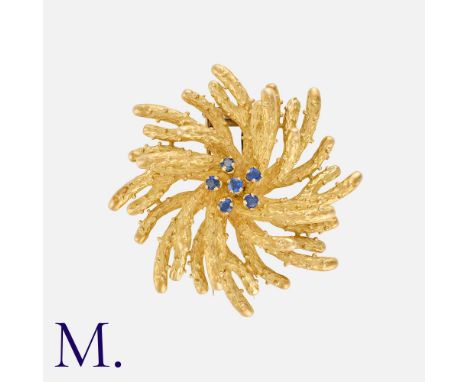 BOUCHERON. A Sapphire Anemone Clip in 18K yellow gold, set with 6 sapphires to the centre of a pleasant sea anemone form.  Si