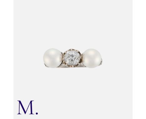 A Diamond and Pearl Ring in platinum, set with two pearls either side of an old cut diamond weighing approximately 0.65ct wit