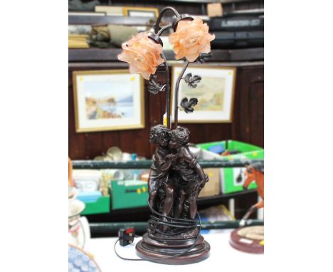 Decorative table lamp with figural base and flower design shade 