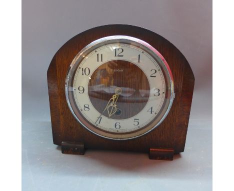 An Enfield oak mantle clock, the silvered chapter ring with Arabic numerals, the plain oak case raised on bracket feet, H. 21