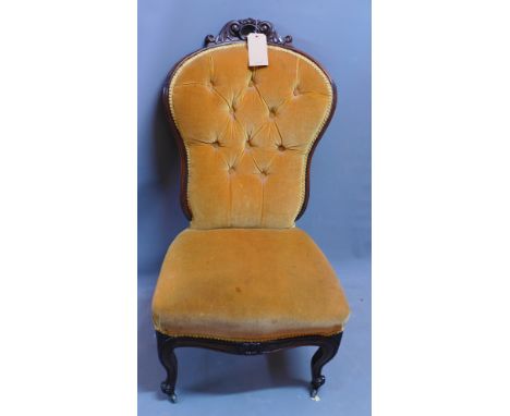 A Victorian mahogany nursing chair, having button back velour upholstery, raised on cabriole legs and castors, H. 102cm