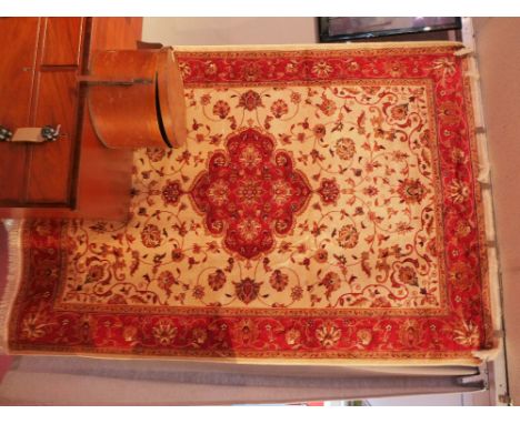 A kashan style carpet with central floral medallion on a beige field contained by repeating borders. 230x160cm 