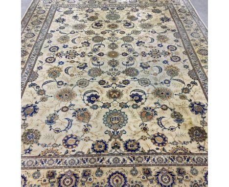 A very fine large persian kashan carpet with central repeating floral motifs on a cream field contained by triple floral bord