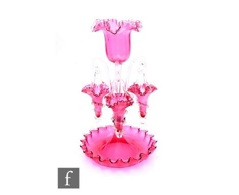 A late Victorian ruby glass epergne, frilled bell shaped central vase on clear glass stem with three scroll hung ruby glass b