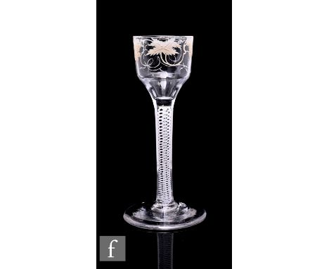 An 18th Century Beilby enamelled drinking glass circa 1765, the ogee bowl painted with fruiting vine in opaque white above a 