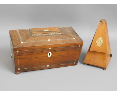 A 19thC. rosewood tea caddy inlaid with mother of pearl, lacking one foot twinned with a metronome, fault to door