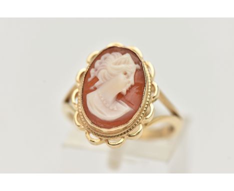 A 9CT GOLD CAMEO RING, carved shell cameo, collet set within a fine rope twist and scallop surround, bifurcated shoulders, le