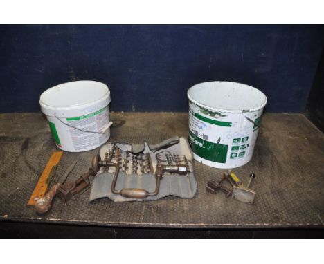 TWO TUBS CONTAINING TOOLS including a brace and bits, a machine vice, two hold down clamps, bevel squares, joiners rules, a R