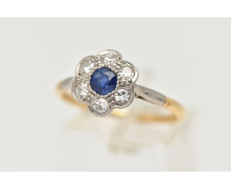 A YELLOW METAL SAPPHIRE AND DIAMOND CLUSTER RING, flower cluster set with a central deep blue, circular cut sapphire, in a su