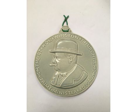 Poole pottery pale blue plaque with a portrait of Sir Winston Churchill with a hat and cigar, and to back the words “we shall