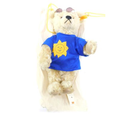 A Steiff mohair Teddy Bear, in a blue t-shirt with sun face, with sun hat and sunglasses, with carry bag.