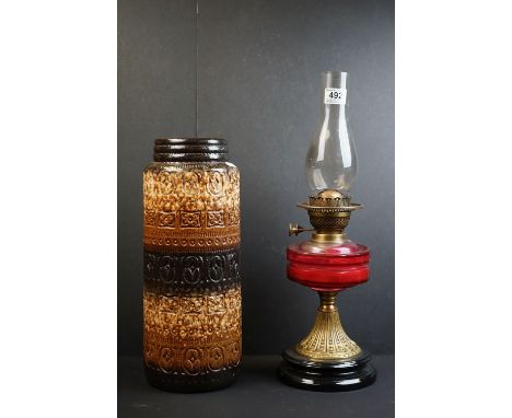 Late 19th / Early 20th century Oil lamp with cranberry glass bowl together with a west German pottery vase. 