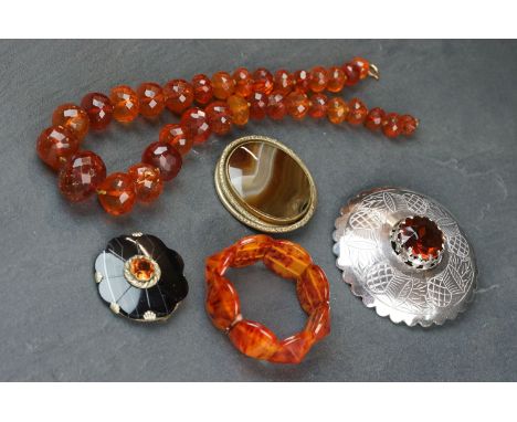 A small quantity of vintage costume jewellery to include amber style beaded necklace and two Scottish style brooches. 