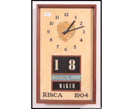 A vintage mid century teak wood retro block date and month wall clock with notation for Barclays and Risca 1904