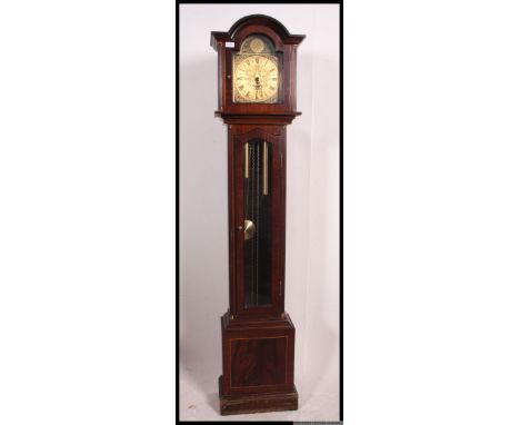 A 20th century mahogany tempus fugit longcase clock with decorative face, brass weights and pendulum