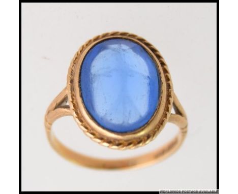 A vintage large ladies 9ct gold and blue sapphire style stone set dress ring. The  oval cut stone on claw mount with 9ct hall