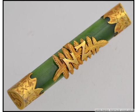 A stunning ladies Jade bar brooch being mounted with 9ct gold having  the New Zealand fern with initials NZ. Total weight 