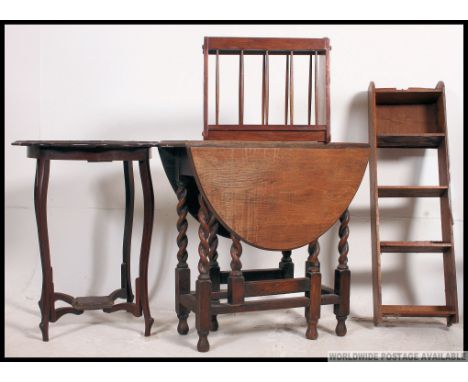 A 1930's oak drop leaf dining table together with a Victorian mahogany lamp table, magazine rack and oak upright bookcase. H7