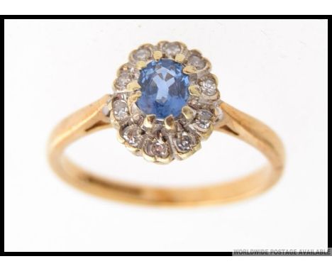 A vintage 9ct gold diamond and aquamarine ladies cluster ring. The ring having a central aquamarine oval cut gemstone surroun