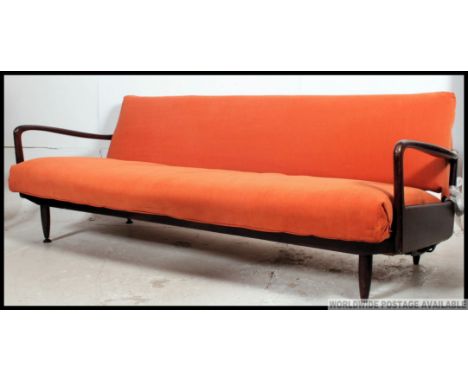 A stunning retro original 1960's teak wood day bed sofa. The turned legs supporting a fold down bed completed by shaped arms 