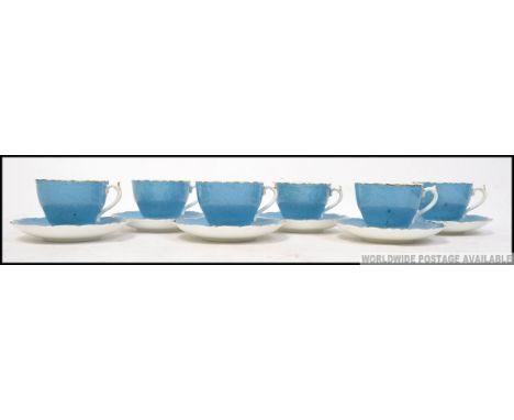 Coalport 6 blue cups and saucers with gilt rim and floral design to interior signed P Gramet